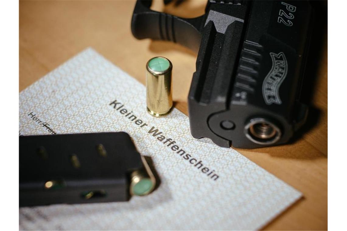 Ein Kleiner Waffenschein liegt zwischen einer Schreckschuss-Pistole und einem Magazin. Foto: Oliver Killig/dpa-Zentralbild/dpa/Symbolbild