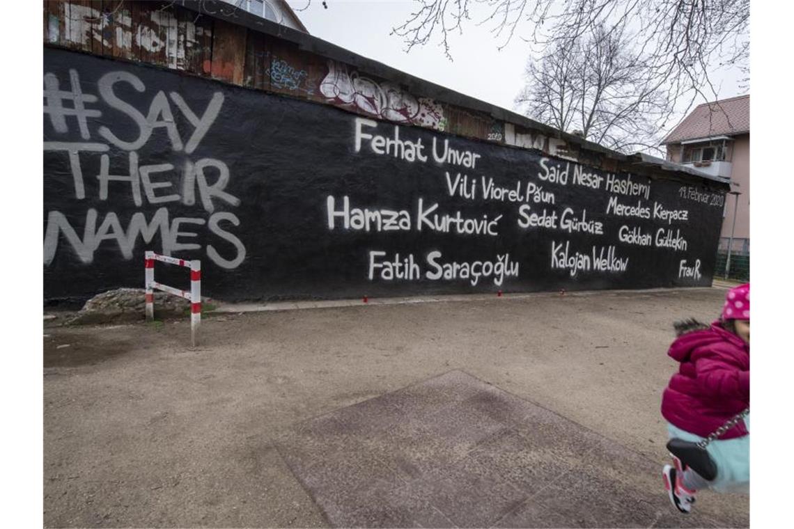 Ein kleines Mädchen schaukelt vor der Wand eines Jugendzentrums, auf dem die Namen der Opfer des Anschlags vom 19. Februar geschrieben stehen. Foto: Boris Roessler/dpa