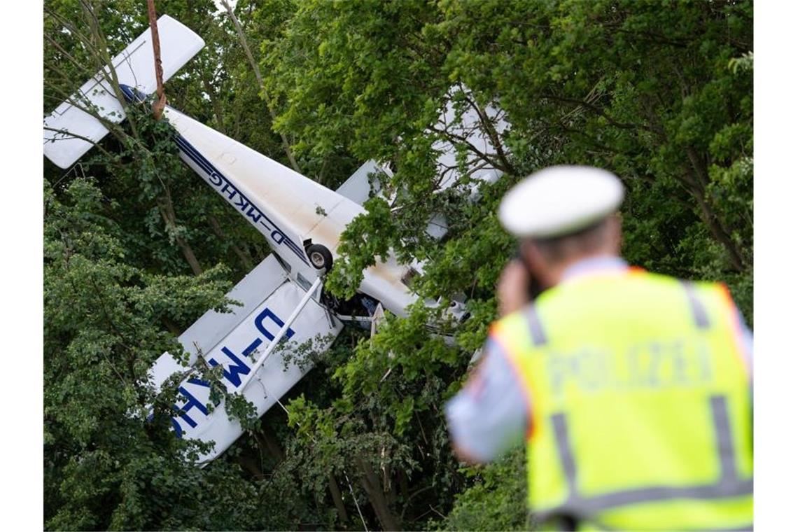 Ein Kleinflugzeug hängt neben einem Flugfeld in den Bäumen. Die beiden Insassen wurden in ein Krankenhaus gebracht. Foto: Marius Becker