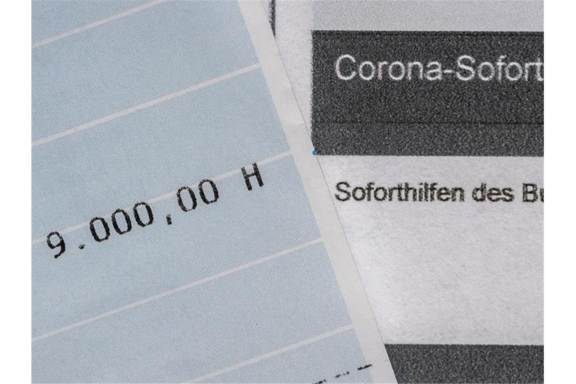 Ein Kontoauszug mit der überwiesenen Summe von 9.000 Euro Corona-Soforthilfe liegt auf einem Antrag für den Zuschuss der Sächsischen Aufbaubank. Foto: Robert Michael/dpa-Zentralbild/dpa
