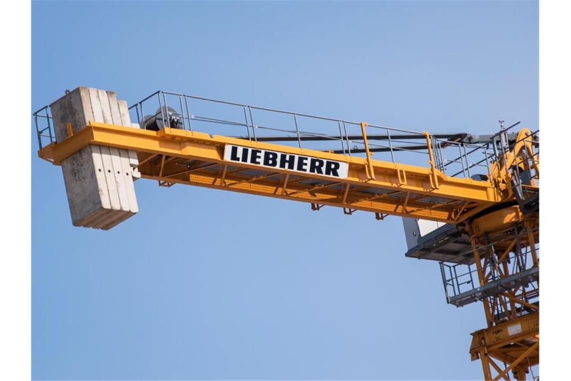 Ein Kran des Herstellers Liebherr steht auf einer Baustelle. Foto: Daniel Bockwoldt/dpa/Archivbild