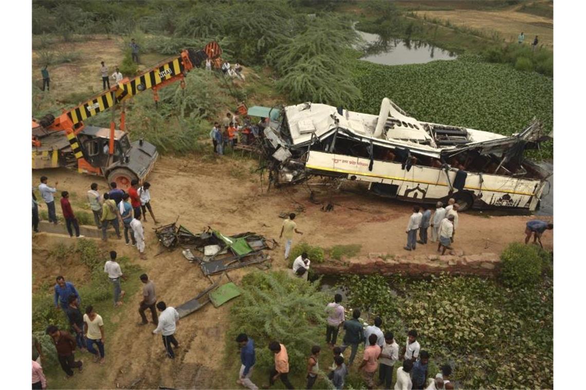 29 Tote bei Busunglück in Nordindien Ein Kran zieht den beschädigten Bus aus dem Abwasserkanal. Foto: Pawan Sharma/AP