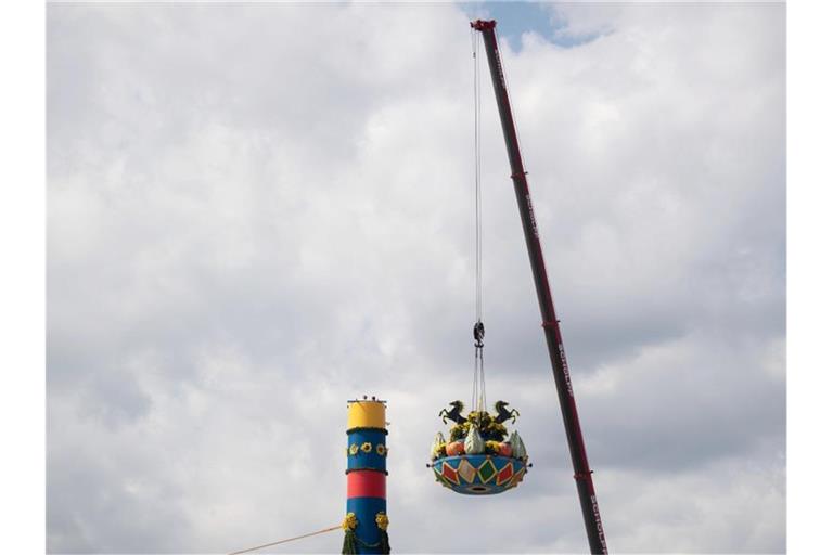Ein Kran zieht während des Aufbaus der Fruchtsäule auf dem Cannstatter Wasen den oberen Teil der Fruchtsäule nach oben. Foto: Marijan Murat