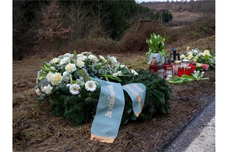 Ein Kranz, Blumen und Kerzen für die getötete Polizistin und ihren Kollegen. Foto: Harald Tittel/dpa