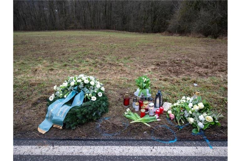 Ein Kranz sowie Blumen und Kerzen liegen am Tatort an der Kreisstraße 22 bei Ulmet (Rheinland-Pfalz). Foto: Harald Tittel/dpa