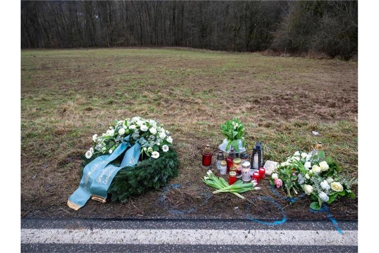 Ein Kranz sowie Blumen und Kerzen liegen am Tatort in Rheinland-Pfalz, wo zwei junge Polizisten getötet wurden. Foto: Harald Tittel/dpa