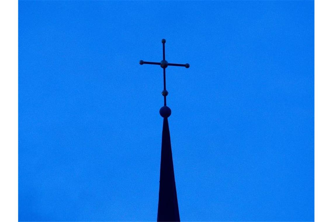 Vollversammlung des Weltkirchenrats wird verschoben Ein Kreuz ist auf einer Kirchturmspitze zu sehen. Foto: Friso Gentsch/dpa/Symbolbild