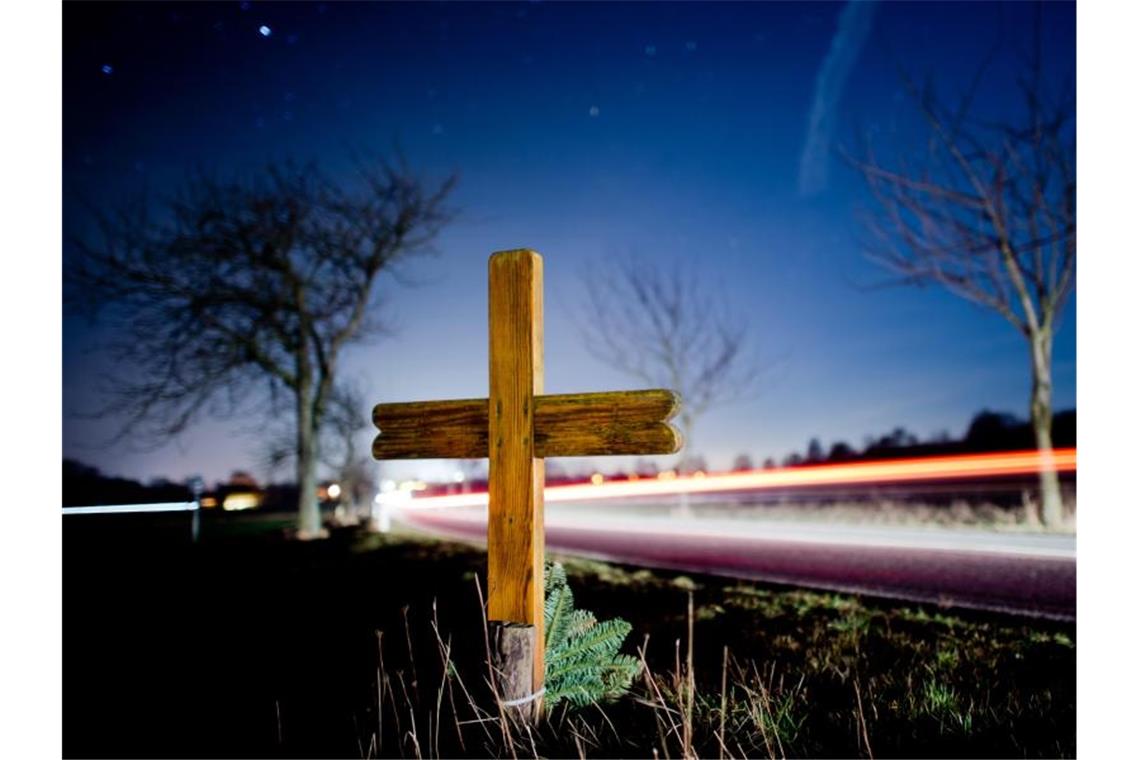 Ein Kreuz zur Erinnerung an einen Verkehrstoten steht an einer Landstraße. Foto: Julian Stratenschulte/Archivbild