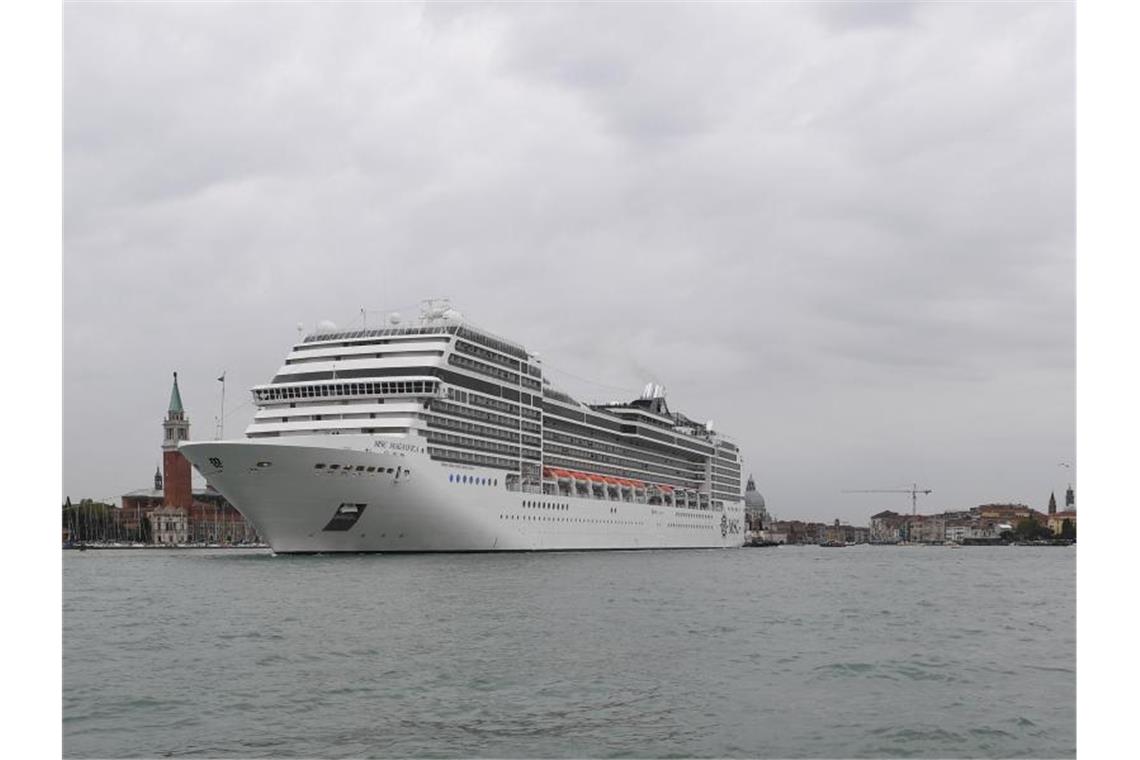 Ein Kreuzfahrtschiff fährt an der Lagunenstadt Venedig von einem Schlepper gezogen vorbei. Foto: Felix Hörhager/dpa