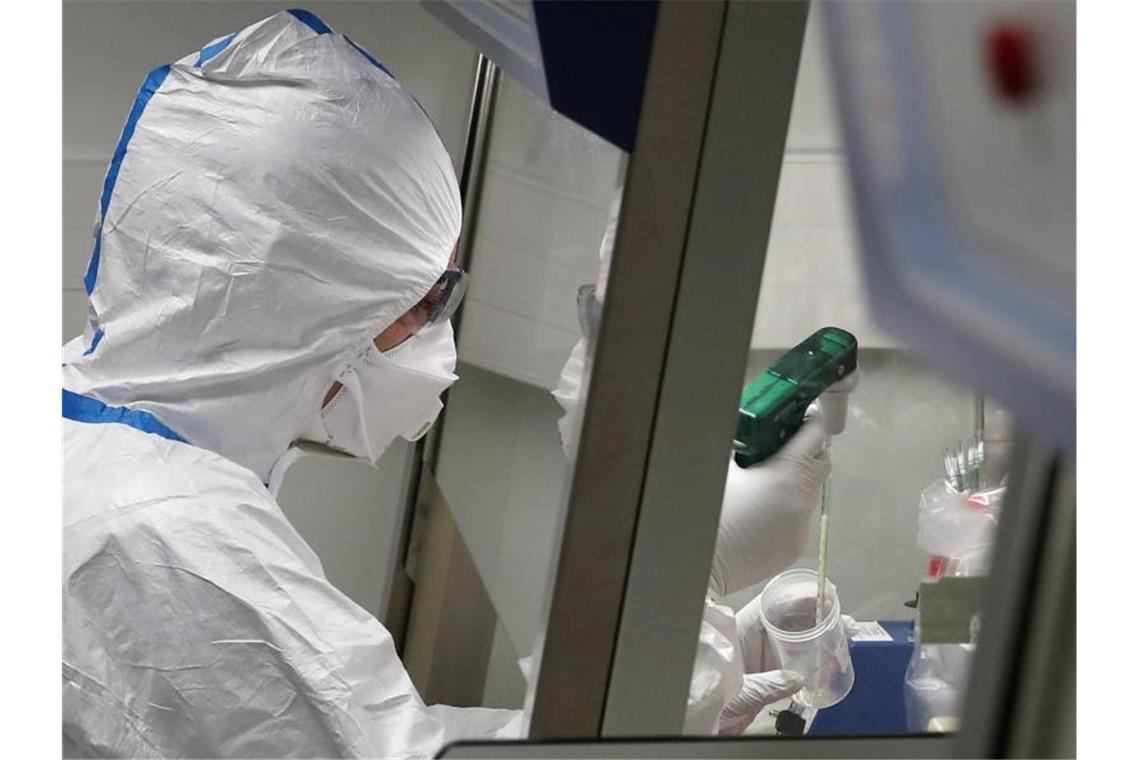 Ein Laborwissenschaftler arbeitet im Institut Pasteur in Paris mit Proben von mit dem Coronavirus infizierten Patienten. Foto: Francois Mori/AP/dpa