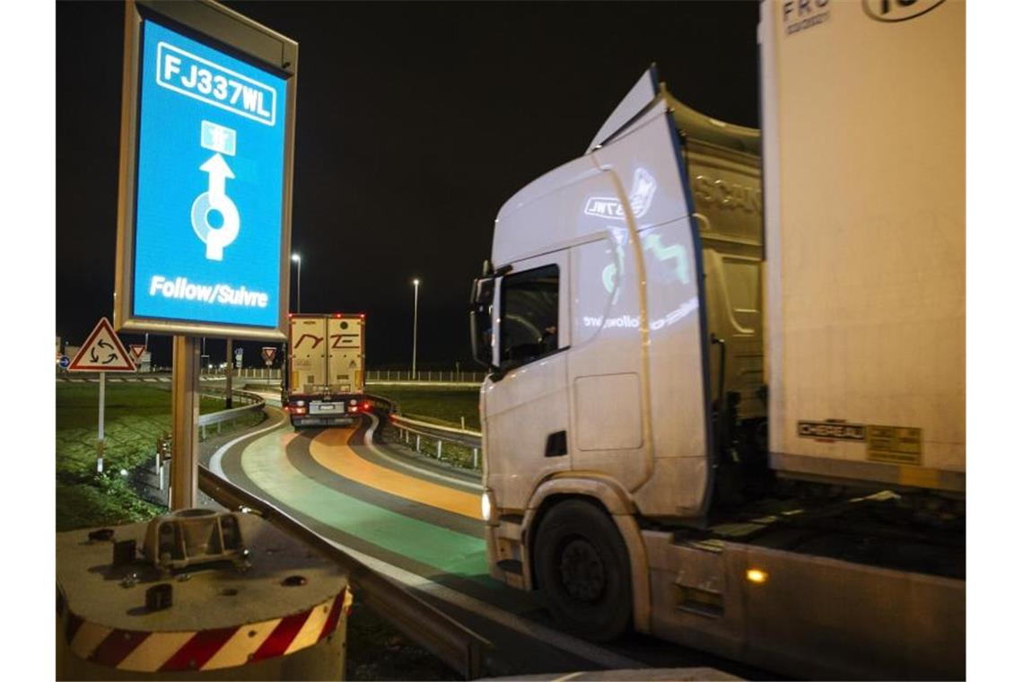 Großbritannien ist raus aus dem EU-Binnenmarkt Ein Lastwagen aus Großbritannien fährt auf dem Weg zum Eurotunnel-Terminal auf einer Straße mit grünen und orangefarbenen Linien, die Teil der neuen "Smart Border"-Zollinfrastruktur ist. Foto: Lewis Joly/AP/dpa
