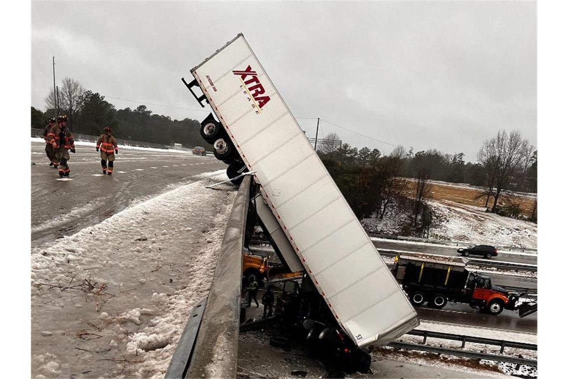 Schnee und Stürme im Osten der USA Ein Lastwagen hängt an der Überführung einer Autobahn. Der Fahrer ist mit seinem Führerhaus aufgrund des Winterwetters von der Straße gerutscht. Foto: Uncredited/Durham Police Department/AP/dpa