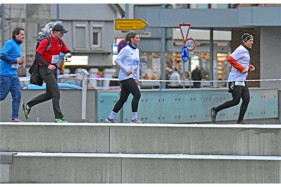 Ein laufender Golfer sowie Svenja und Achim (von links) laufen an der Murrtreppe...