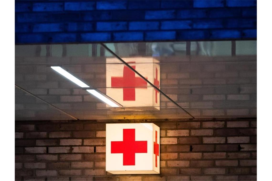 Mann stürzt bei Reinigungsarbeiten drei Meter in die Tiefe Ein Leuchtkasten mit einem roten Kreuz hängt vor der Notaufnahme eines Krankenhauses. Foto: Julian Stratenschulte/dpa/Symbolbild