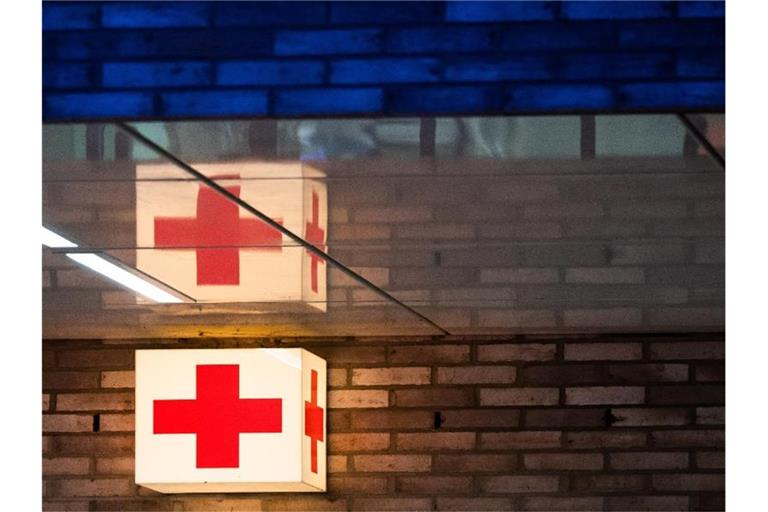 Ein Leuchtkasten mit einem roten Kreuz hängt vor der Notaufnahme eines Krankenhauses. Foto: Julian Stratenschulte/dpa/Symbolbild