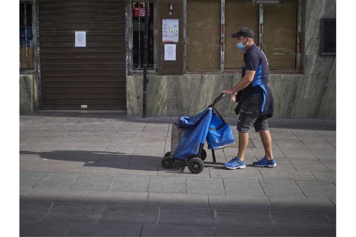 Ein Lieferant geht vor einer Bar im spanischen Peralta vorbei, die geschlossen ist, um die Verbreitung des Coronavirus zu verhindern. Foto: Eduardo Sanz/EUROPA PRESS/dpa