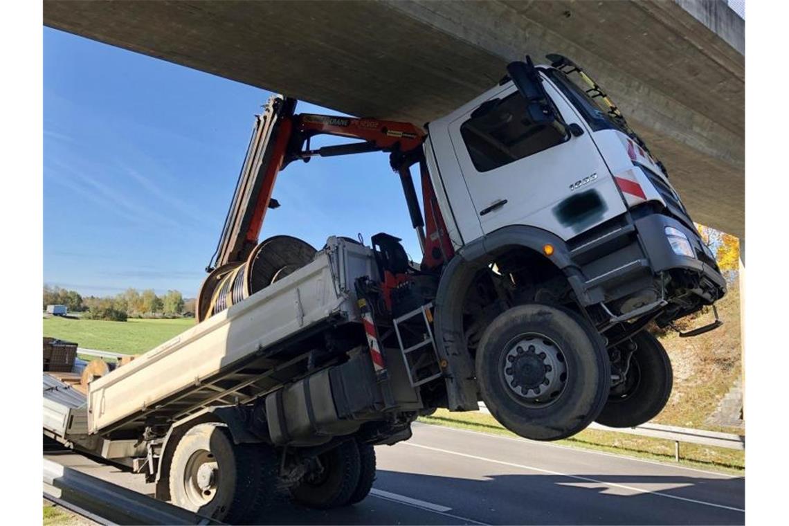 80-Jähriger bleibt mit Lkw spektakulär an Brücke hängen Ein Lkw bleibt mit seinem Ladekran an einer Brücke hängen. Foto: Hermann Spanner/Feuerwehr Bichl/dpa