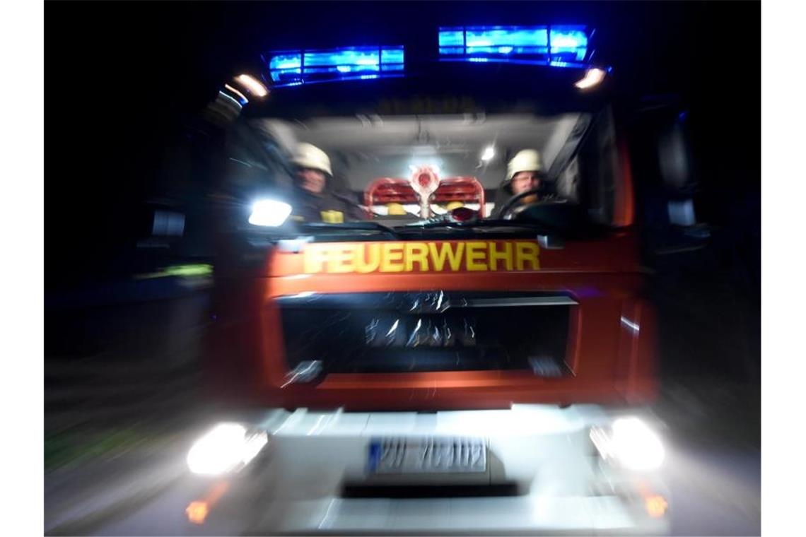 Ein Löschfahrzeug fährt mit Blaulicht über eine Straße. Foto: Carsten Rehder/dpa/Archivbild