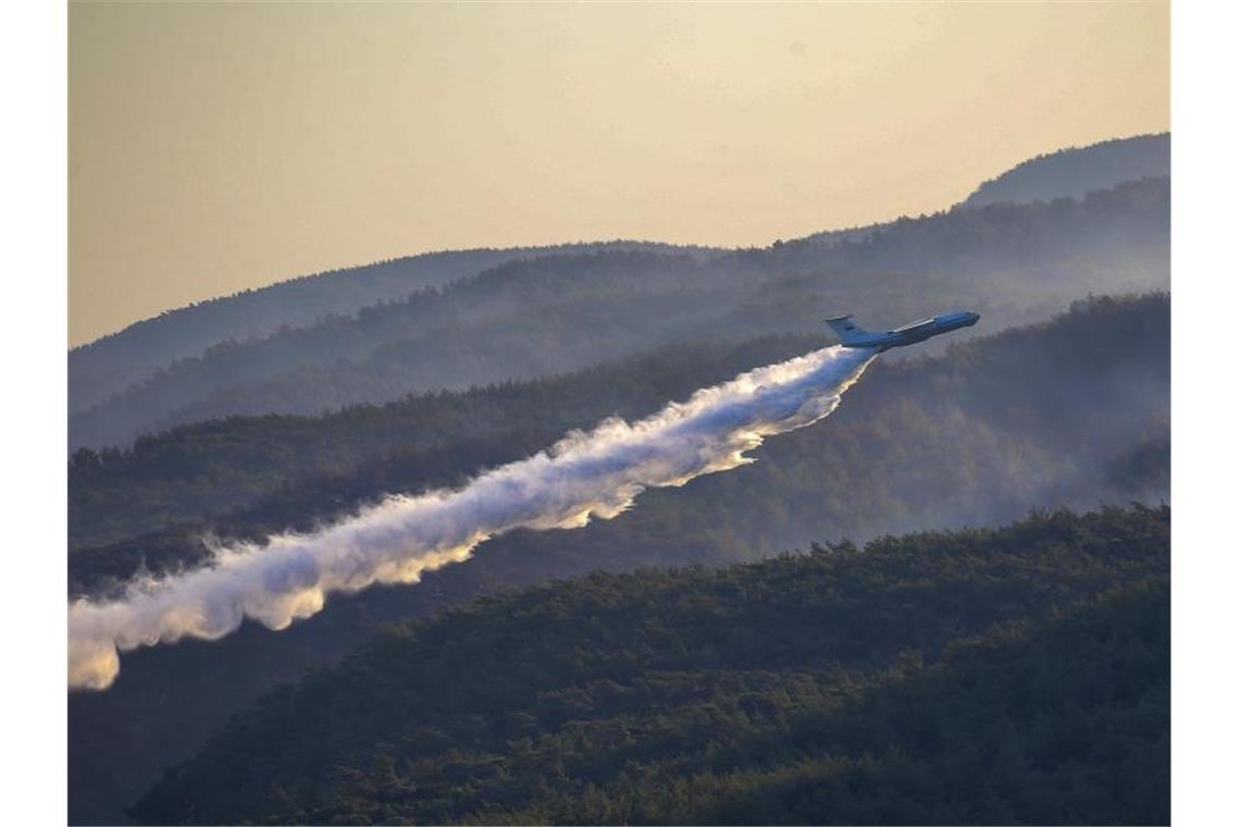 Leichte Entspannung bei Bränden in Griechenland Ein Löschflugzeug der türkischen Streitkräfte wirft über einem Waldbrand in der Provinz Mugla im Süden der Türkei Wasser ab. Foto: Emre Tazegul/AP/dpa