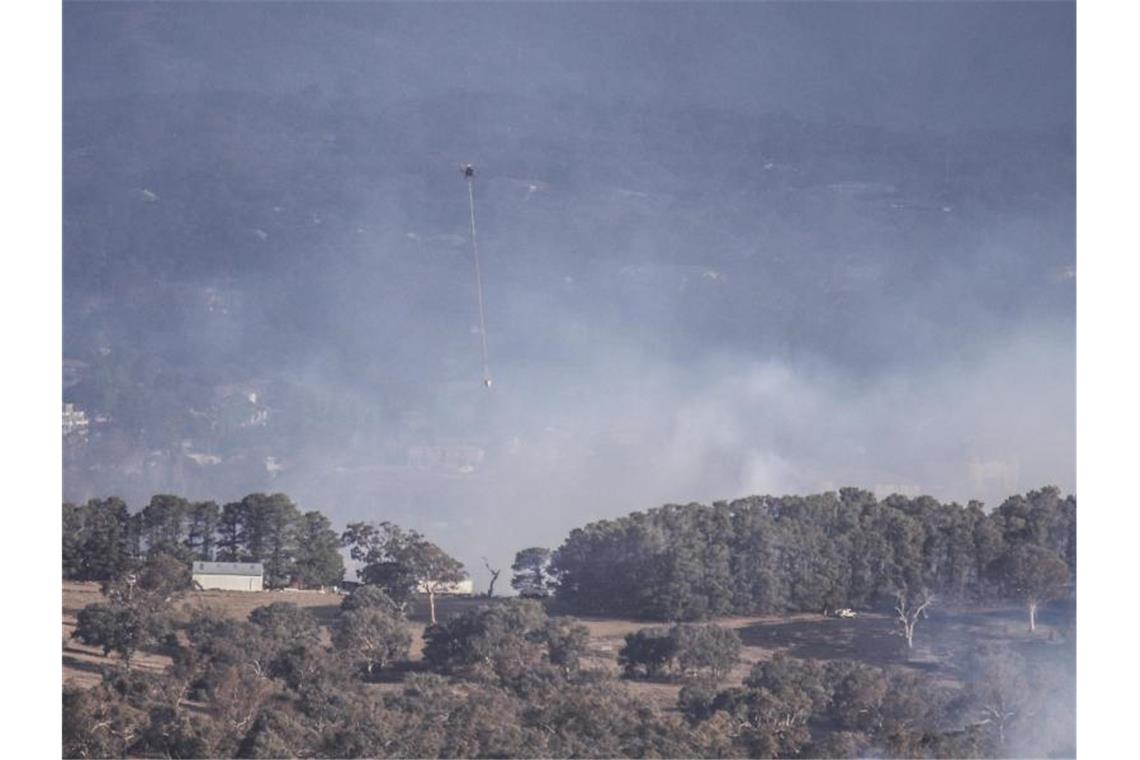 Ein Löschhubschrauber ist bei einem Buschfeuer in der Nähe der australischen Hauptstadt Canberra im Einsatz. Foto: Liu Changchang/XinHua/dpa