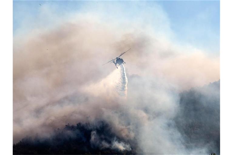 Ein Löschhubschrauber ist in Keratea südöstlich von Athen im Einsatz. Foto: Marios Lolos/XinHua/dpa