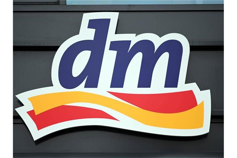 Ein Logo der Drogeriemarktkette dm, aufgenommen an einer Filiale. Foto: Uli Deck/dpa/Aktuell