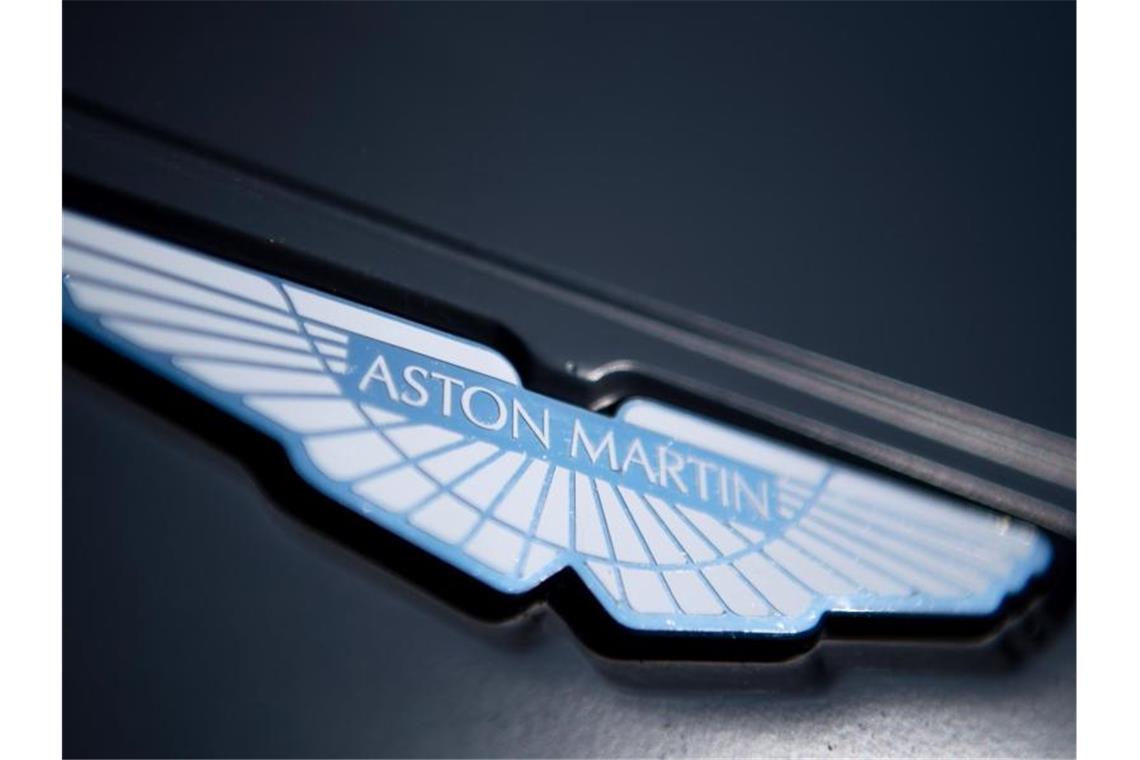 Ein Logo des Autoherstellers Aston Martin ist an der Motorhaube eines Rennwagens angebracht. Foto: Monika Skolimowska/dpa-Zentralbild/dpa/Archivbild