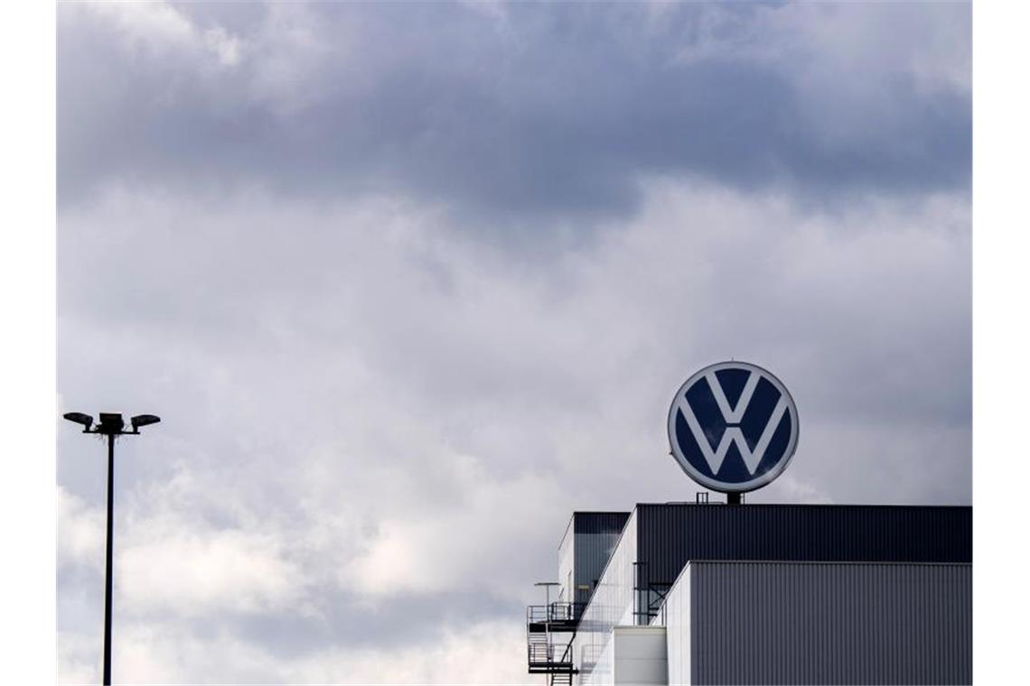 Ein Logo von Volkswagen dreht sich auf einem Werk. Foto: Julian Stratenschulte/dpa