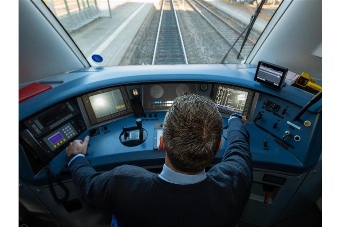 Ein Lokführer im Führerstand eines Diesel-Triebwagens der Deutschen Bahn. Foto: Daniel Karmann/dpa/Symbolbild