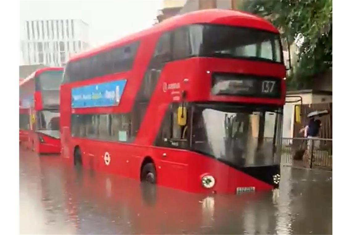 Ein Londoner Bus auf einer überschwemmten Straße. Foto: Hebe Campbell/PA Media/dpa