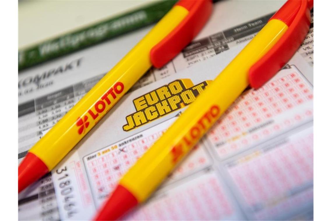 Ein Los für den Eurojackpot und ein Kugelschreiber liegen in einer Lotto-Annahmestelle. Foto: Patrick Seeger/dpa/Archivbild