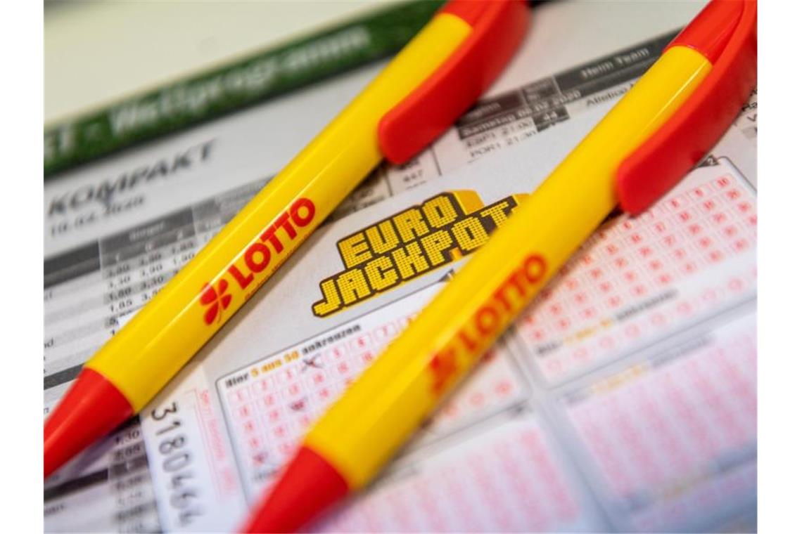 Ein Los für den Eurojackpot und Kugelschreiber mit dem Lotto-Logo. Foto: Patrick Seeger/dpa/Symbolbild