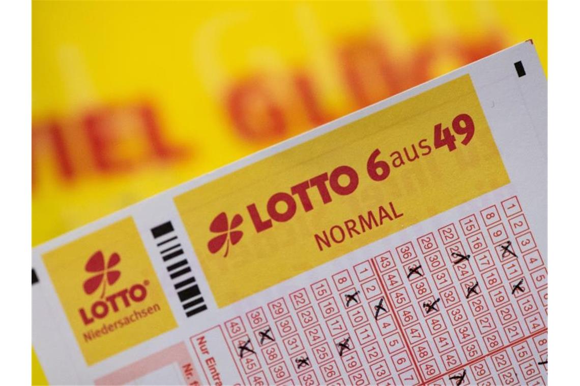 Ein Lottoschein ist vor dem Schriftzug „Viel Glück“ zu sehen. Foto: Swen Pförtner/dpa/Symbolbild