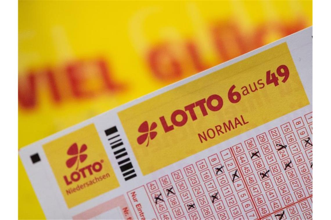Ein Lottoschein mit der Aufschrift "Lotto 6 aus 49" ist vor einem Schriftzug "Viel Glück" zu sehen. Foto: Swen Pförtner/dpa/Archivbild