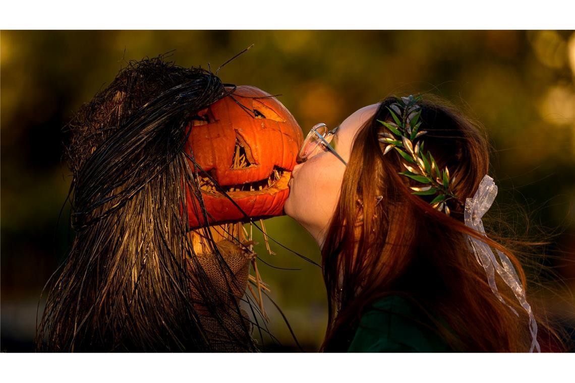 Ein Mädchen posiert für einen Freund und küsst einen Kürbis auf dem West Side Hallo Fest, dem größten Halloween-Festival des Landes, in Bukarest.