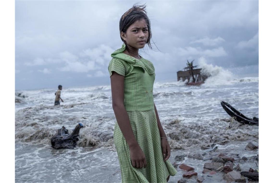 Ein Mädchen steht vor den Überresten von ihrem Teeladen, der durch das Meerwasser auf der Insel Namkhana völlig zerstört ist. Das Foto von Fotograf Supratim Bhattacharjee erhält den ersten Preis beim internationalen Wettbewerb Unicef-Foto des Jahres 2021 des UN-Kinderhilfswerks Unicef. Foto: Supratim Bhattacharjee, Indien/UNICEF/dpa
