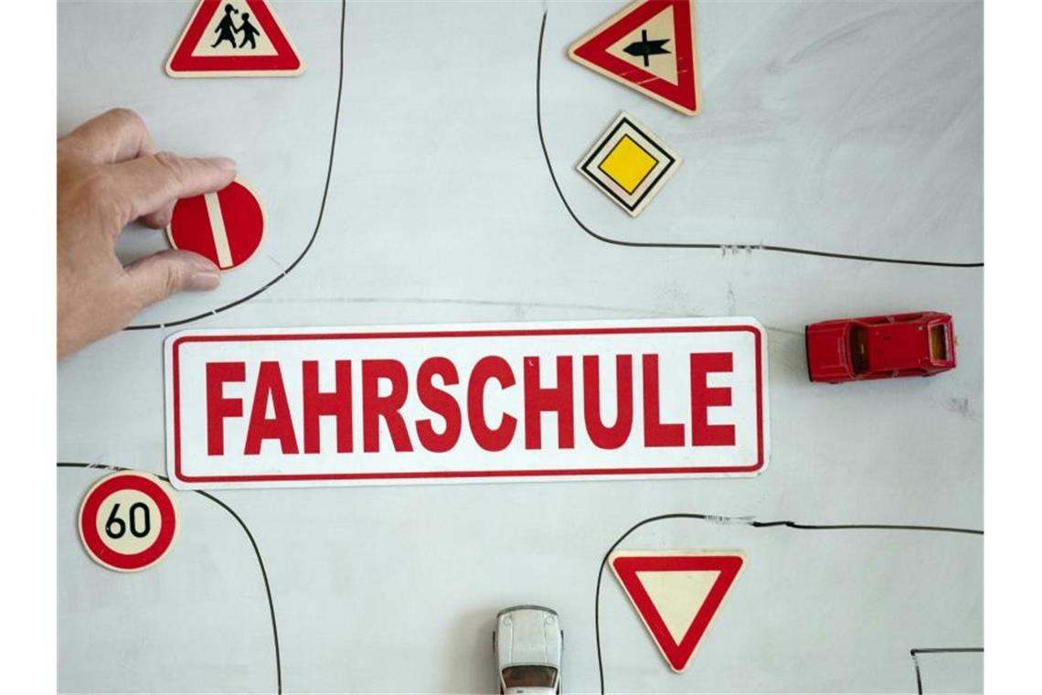 Gericht: Theorie-Fahrunterricht in Präsenz wieder erlaubt Ein Magnet mit der Aufschrift „Fahrschule“ an einer Wandtafel mit verschiedenen Verkehrsymbolen. Foto: Swen Pförtner/dpa/Symbolbild
