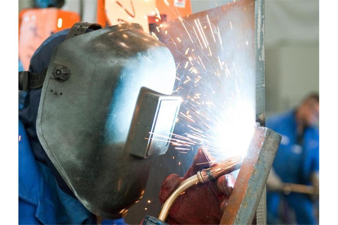 Ein Mann arbeitet an einer Stahlwand. Foto: Robert Schlesinger/dpa-Zentralbild/dpa