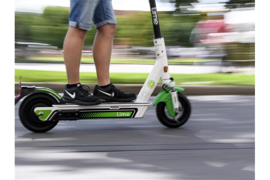 Ein Mann auf einem E-Scooter des Anbieters „Lime“ in Stuttgart. Foto: Edith Geuppert/dpa