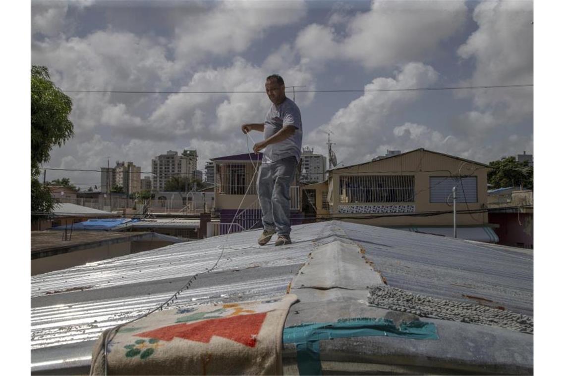 Tropensturm steuert auf Puerto Rico und Florida zu Ein Mann befestigt in San Juan sein Dach vor der erwarteten Ankunft des Tropensturms „Dorian“. Foto: Gianfranco Gaglione/AP