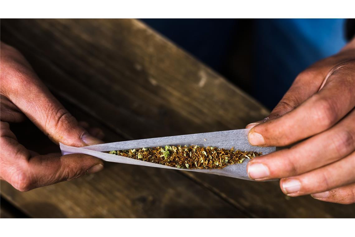 Ein Mann beim Drehen einer Cannabis-Zigarette