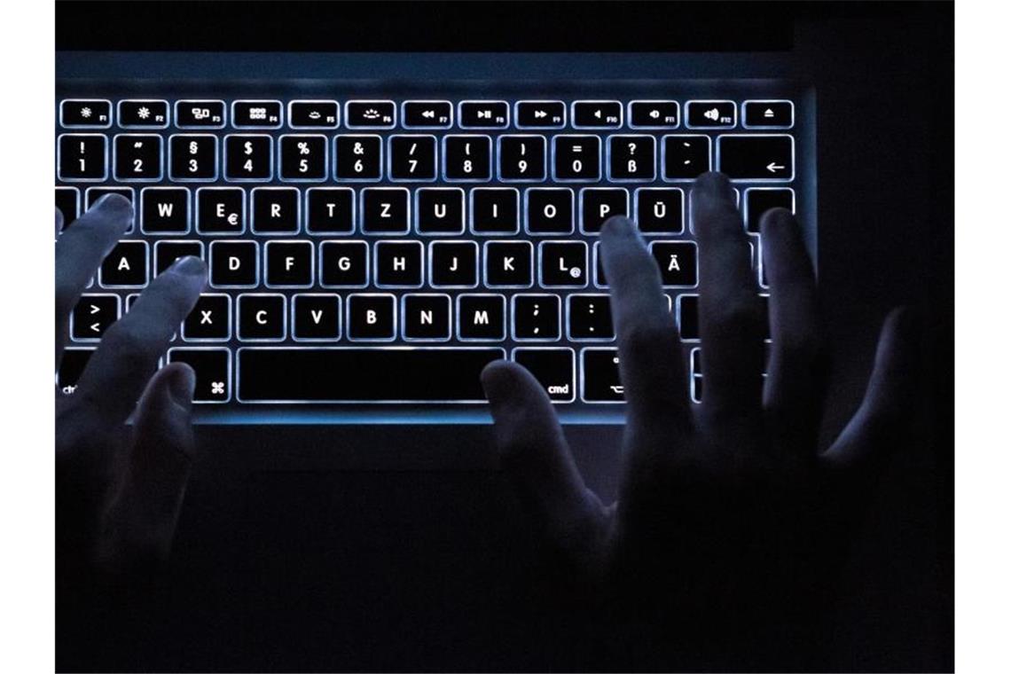 Ein Mann benutzt die beleuchtete Tastatur eines Notebooks. Foto: Silas Stein/Archivbild