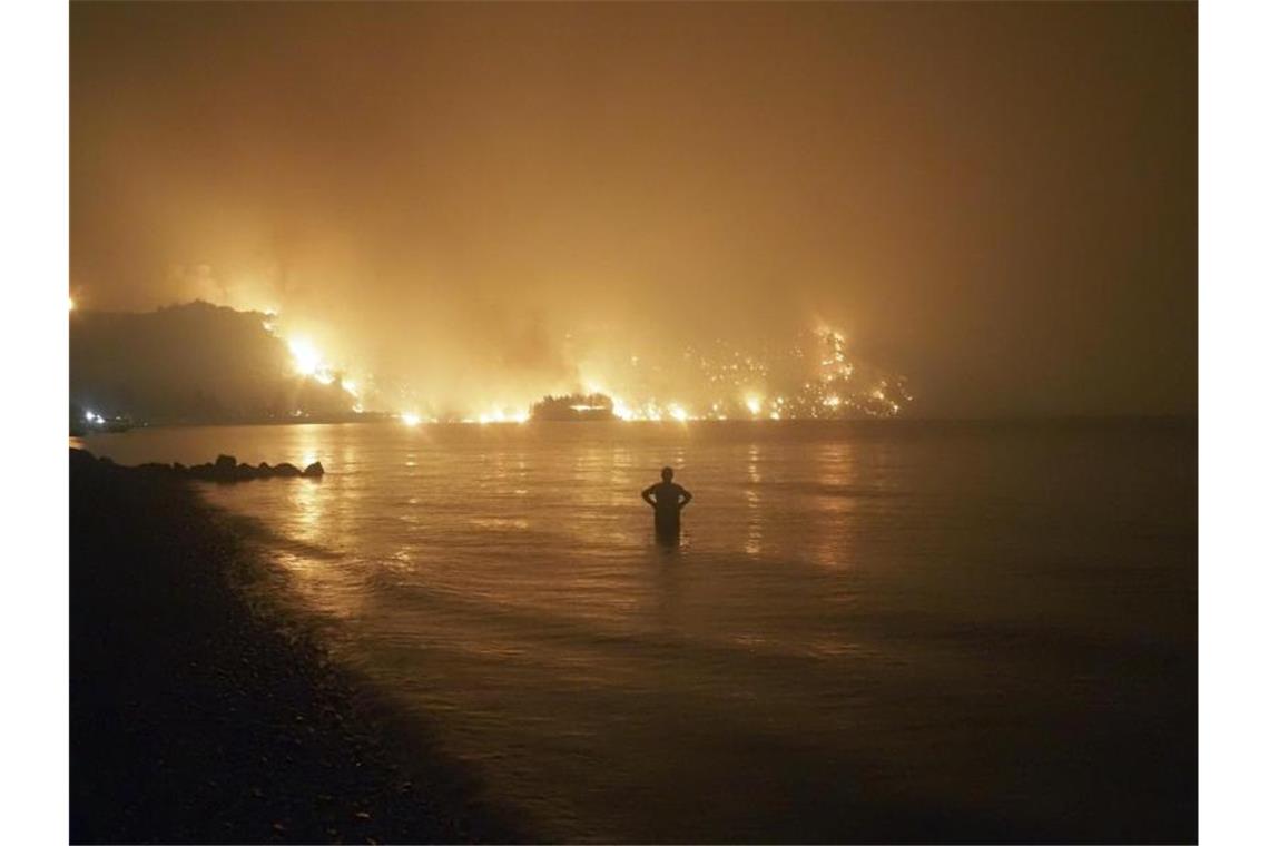 Klimarat: Milliarden Menschen gefährdet Ein Mann beobachtet im August 2021, wie sich Waldbrände dem Strand von Kochyli in der Nähe des Dorfes Limni auf der Insel Evia (Griechenland) nähern. Foto: Thodoris Nikolaou/AP/dpa