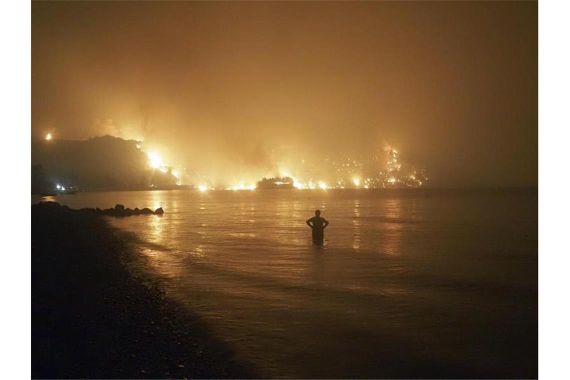 Hitze, Stürme, Fluten - Die Klimakrise ist längst da Ein Mann beobachtet Waldbrände auf der griechischen Insel Evia. Im Sommer wüteten in mehreren Teilen Südeuropas verheerende Feuer. Foto: Thodoris Nikolaou/AP/dpa