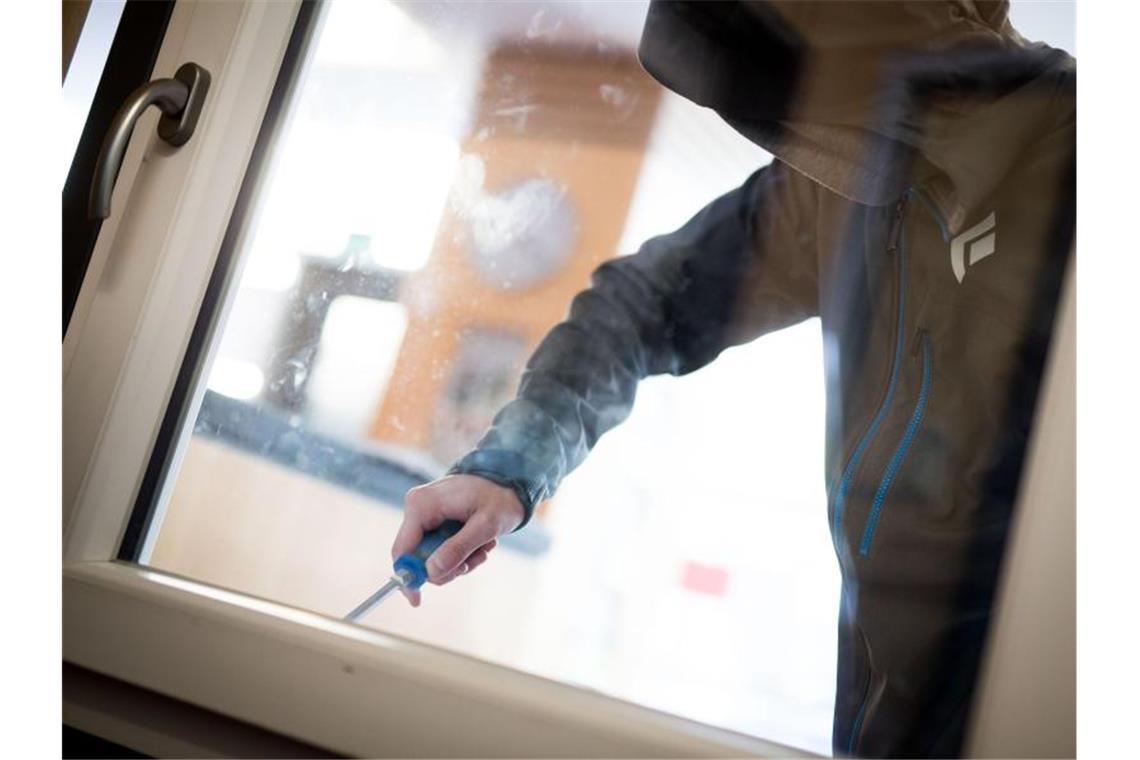 Ein Mann demonstriert in der polizeilichen Beratungsstelle, wie einfach es für einen Einbrecher wäre, mit Hilfe eines stabilen Schraubenziehers ein geschlossenes Fenster von außen zu öffnen. Foto: Frank Rumpenhorst/dpa