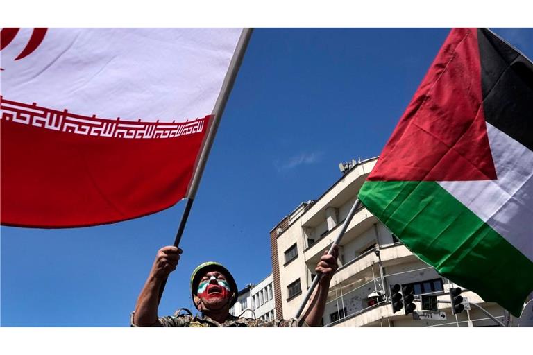 Ein Mann, dessen Gesicht in den Farben der iranischen Fahne bemalt ist, skandiert Slogans, während er die iranische Fahne bei der jährlichen Kundgebung zum Al-Quds-Tag oder Jerusalem-Tag zur Unterstützung der Palästinenser schwenkt.