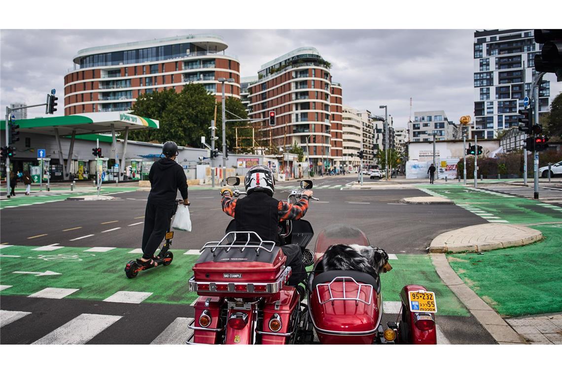 Ein Mann fährt auf seinem Motorrad mit seinem Hund in Tel Aviv, Israel.