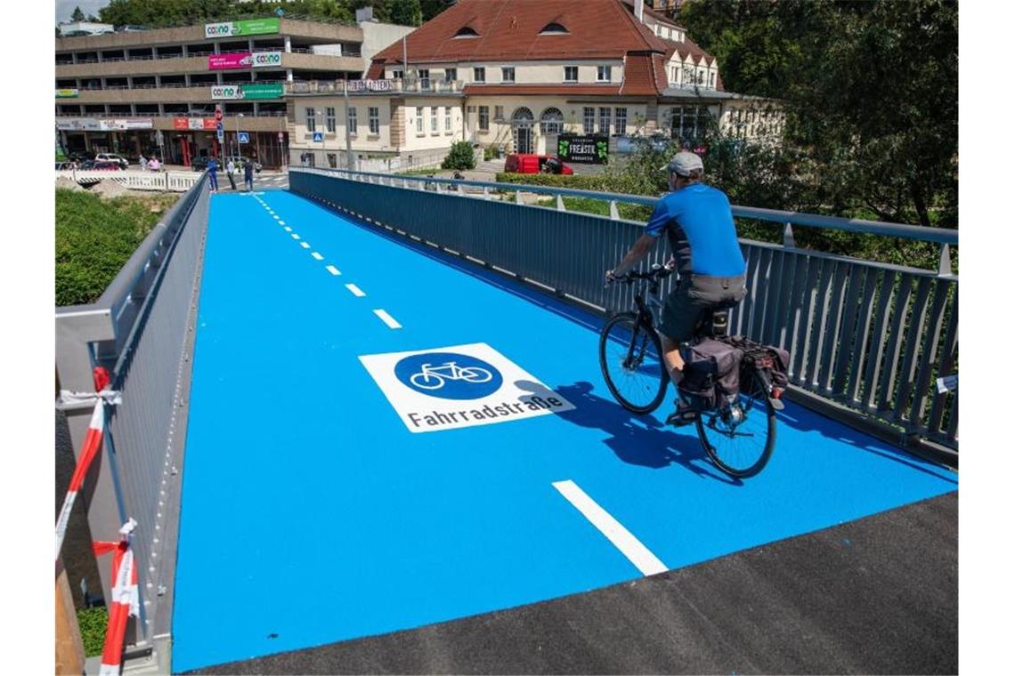 Erste Fahrradbrücke mit „Fußbodenheizung“ eröffnet Ein Mann fährt mit seinem Fahrrad über eine neu eröffnete und beheizbare Radbrücke. Foto: Christoph Schmidt/dpa