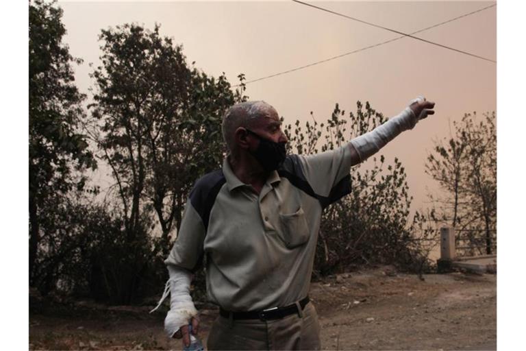 Ein Mann flieht aus einem Dorf in der Nähe von Tizi Ouzou, etwa 100 km östlich von Algier. Foto: Fateh Guidoum/AP/dpa