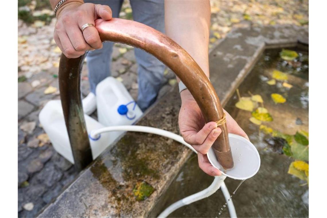 Q wie Quellen: Großes Mineralwasservorkommen in Stuttgart Ein Mann füllt am Auquellbrunnen Mineralwasser in Trinkwasserkanister ab. Foto: Marijan Murat/dpa